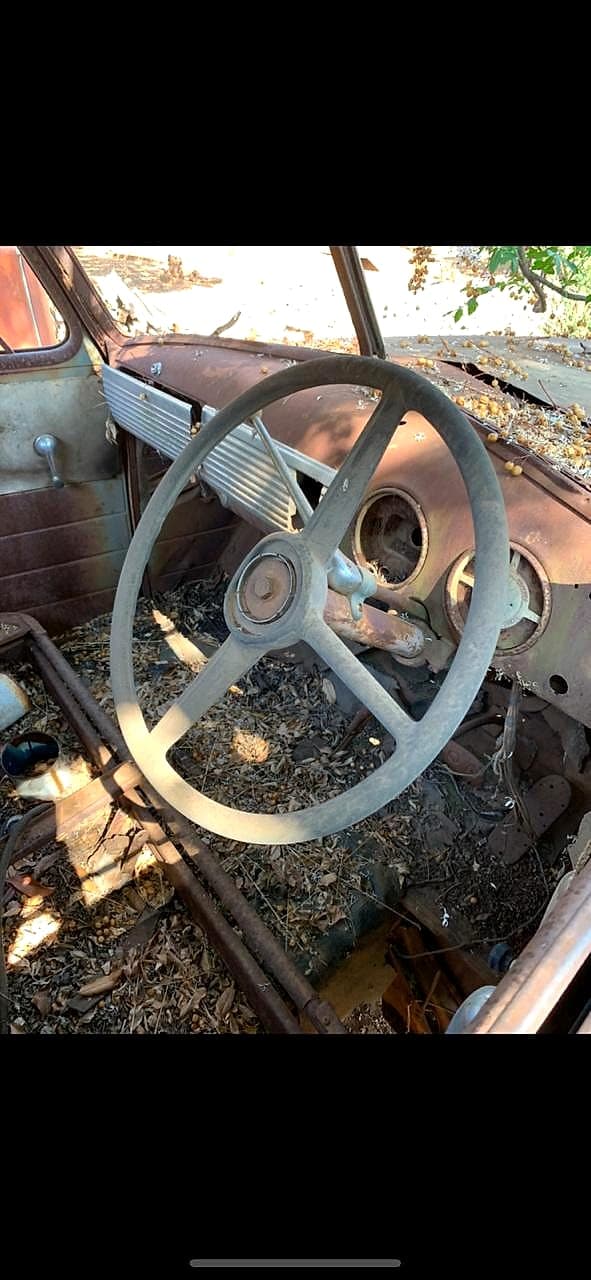Derelict classic car interior with large steering wheel