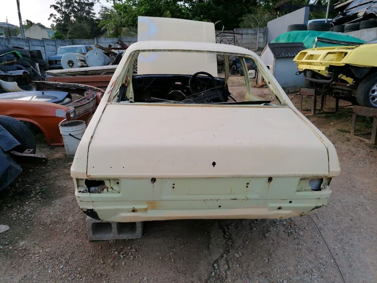 Bare Ford Escort shell with straight rust-free panels in a Southern African yard